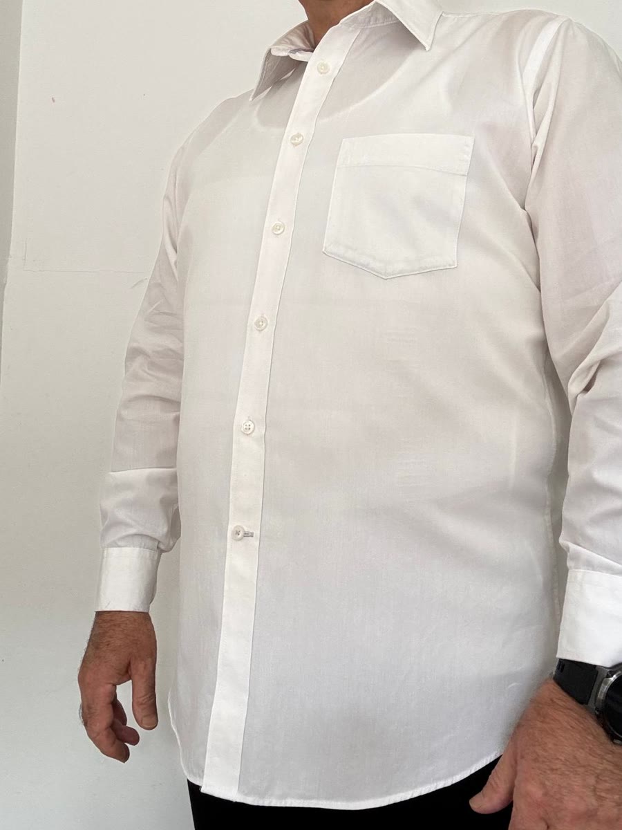 Chemise blanche fine, débardeur porté dessous. Photo réelle, non retouchée.
